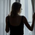 Rear view of a woman standing by the window