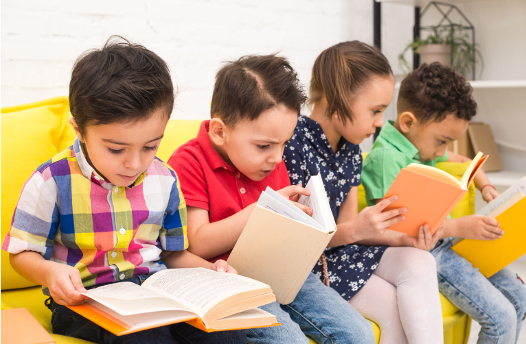grupo de 4 niños leyendo interesados